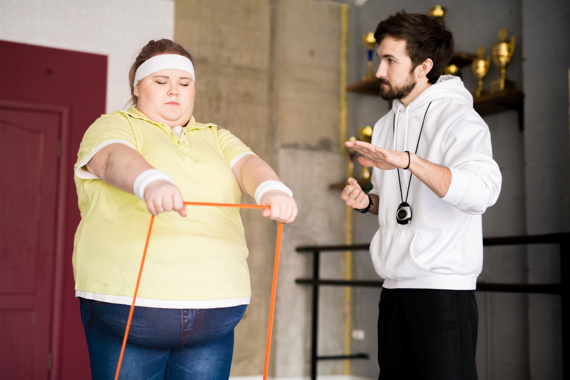 Obese Young Woman Training with Instructor